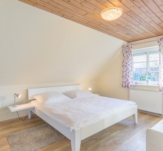 Schlafzimmer mit Bett und Fenster-Dania13 - Ferienhaus / Ferienwohnung Büsum -  15