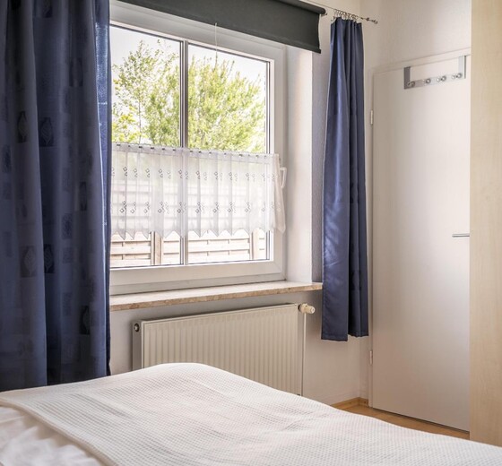 Schlafzimmer mit Bett und Fenster-Moiken - Ferienhaus / Ferienwohnung Büsum -  16