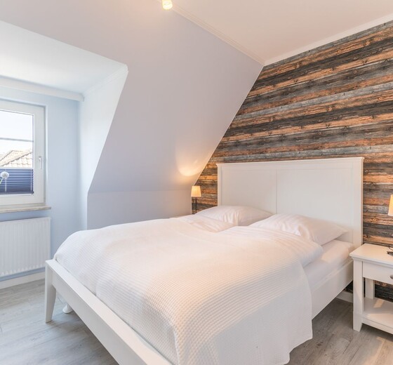 Schlafzimmer mit Bett und Fenster-Diekkieker - Ferienhaus / Ferienwohnung Büsum -  8