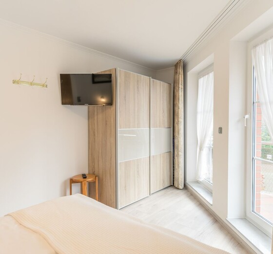 Schlafzimmer mit TV-Residenz Rosengrund, Whg. E 6 - Ferienhaus / Ferienwohnung Büsum -  8