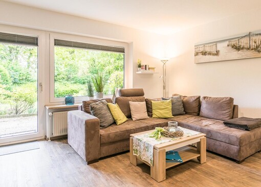 Wohnzimmer mit Sofa und Zugang zur Terrasse-Ferienwohnung Bamberger`s - Ferienhaus / Ferienwohnung Büsumer Deichhausen - 1