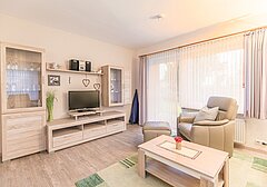 Wohnzimmer mit Sessel und TV-Am Altenhof Whg. 3 - Ferienhaus / Ferienwohnung Büsum - 3