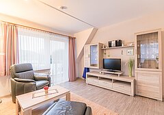 Wohnzimmer mit Fernseher-Am Altenhof Whg. 4 - Ferienhaus / Ferienwohnung Büsum - 3