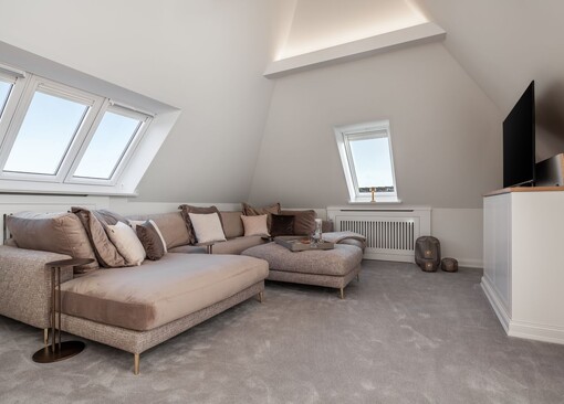Wohnzimmer mit Sofa und TV-WOLKEN.NEST Penthouse-Suite - Ferienhaus / Ferienwohnung Büsum - 1