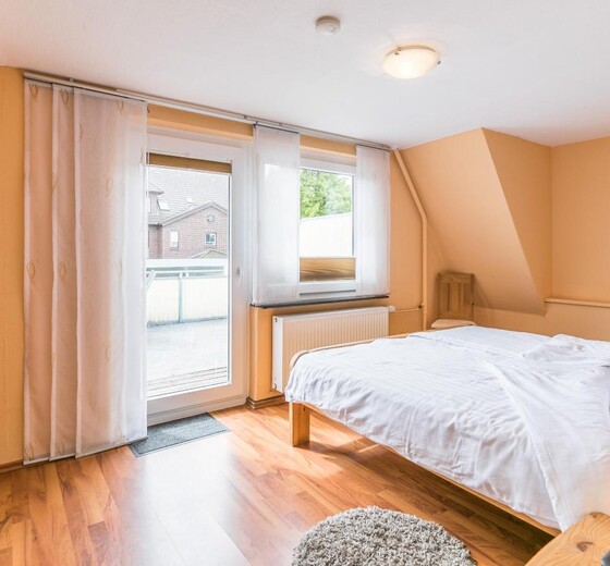 Schlafzimmer mit Zugang zum Balkon-Haus Blomberg - Ferienhaus / Ferienwohnung Büsum -  27