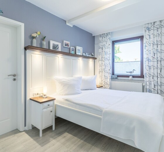 Schlafzimmer mit Bett und Fenster-Wohnung Möwennest - Ferienhaus / Ferienwohnung Büsum -  10