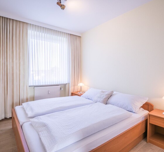 Schlafzimmer mit Bett und Fenster-Nordseekante, Whg. 385 - Ferienhaus / Ferienwohnung Büsum -  9