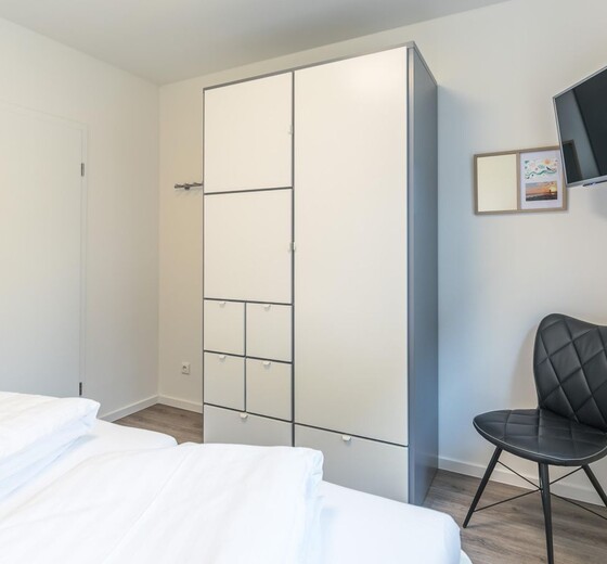 Schlafzimmer 1 mit Kleiderschrank und TV-Strandtraum - Ferienhaus / Ferienwohnung Büsum -  7